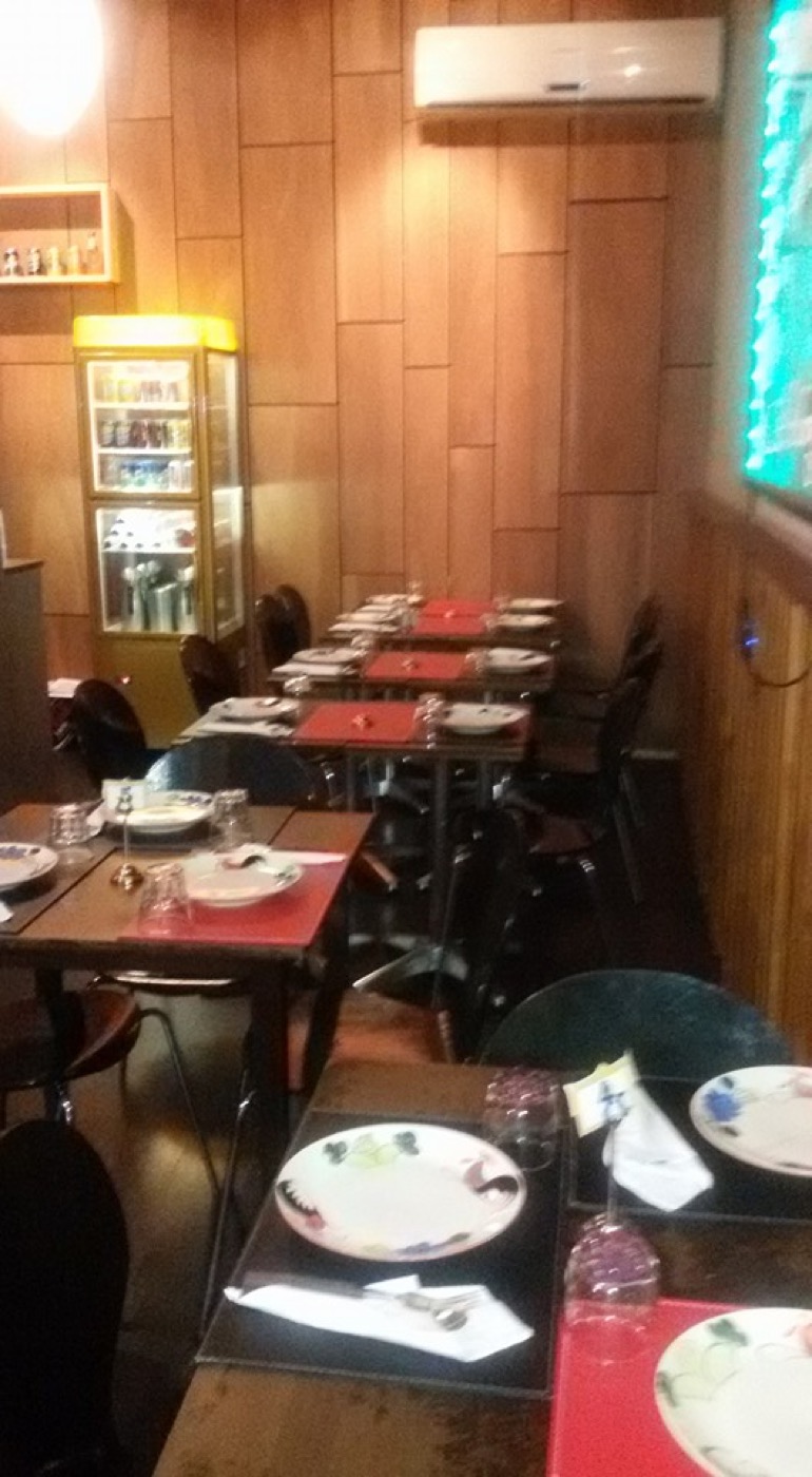 The dining room: dark timber tables set with red place mats and colourful plates, with wood-panelled walls