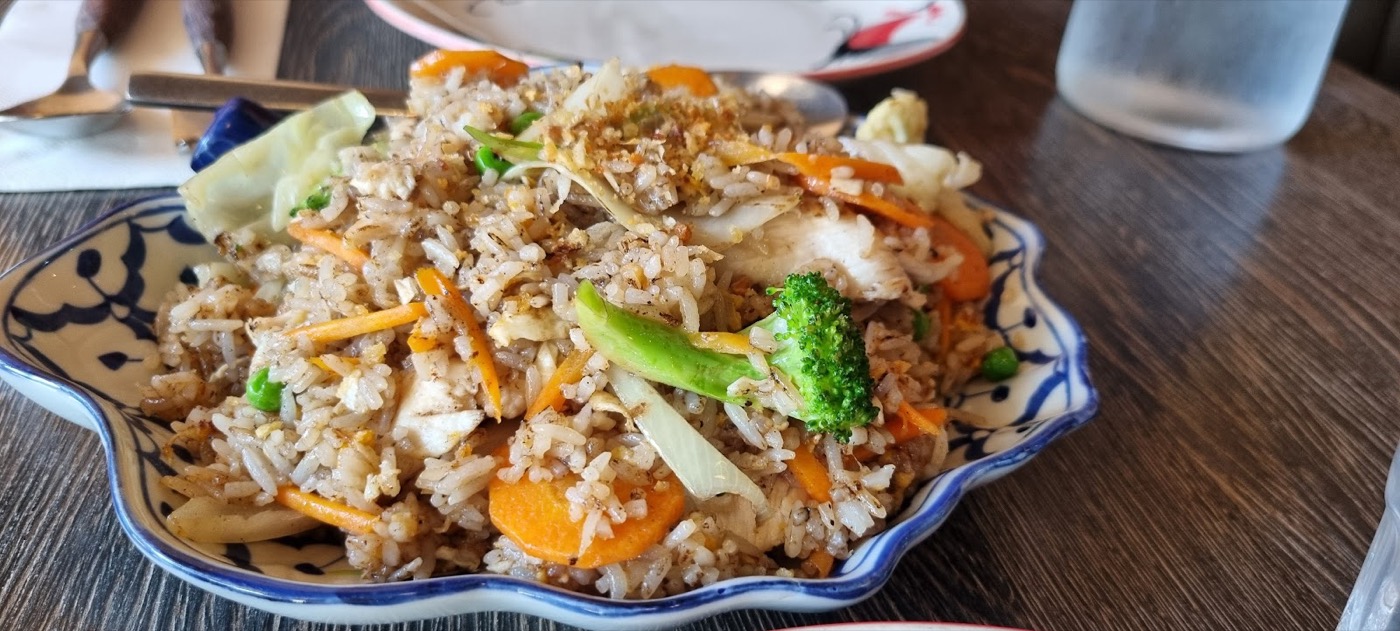 Fried rice with carrot and broccoli on a blue-and-white scalloped plate
